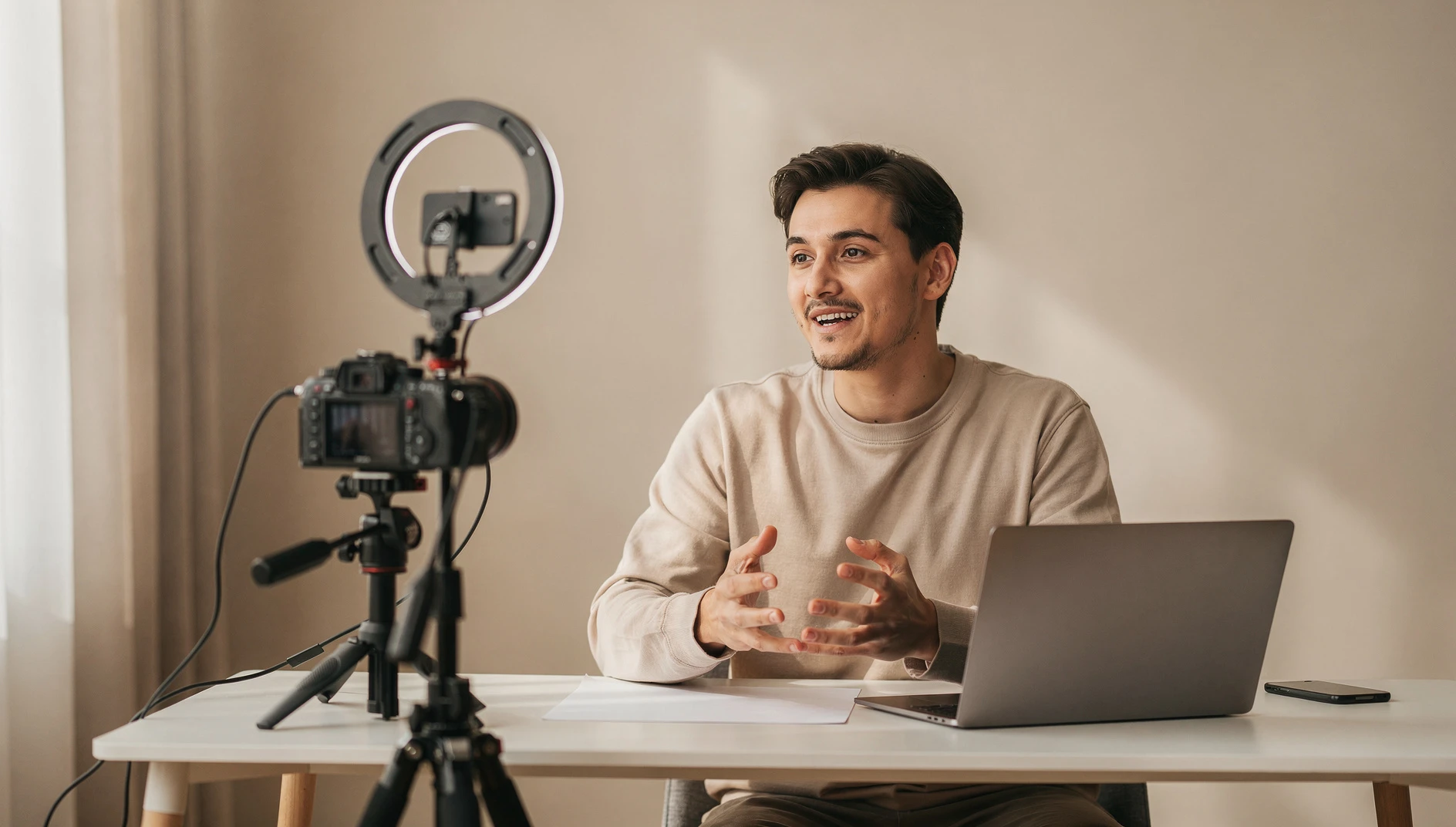 A person recording a tutorial video at a home studio setup with a ring light and clean background
